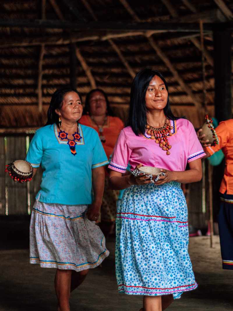 Kichwa women in traditional dress dance together during a community gathering in Ecuador's Amazon.